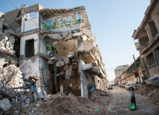 Slovenija podvojila pomoč palestinskim beguncem v luči napadov Gaza City, Occupied Palestinian Territories - December 2, 2012: A child passes a bombed-out residential block in the Al-Zeitoun neighborhood of Gaza City.