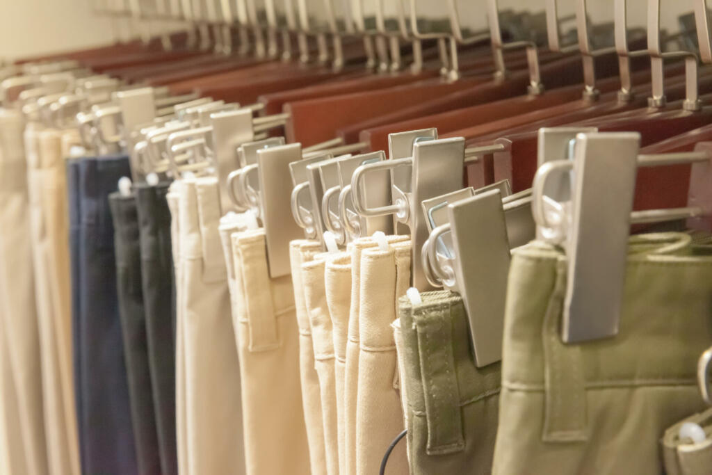 Group of sage pants on hanger at retail shop