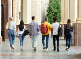 Vrste študija: Katere različice študija poznamo? Group of students walking in college campus after classes, back view