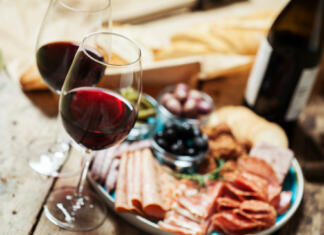 Kaj je osmica? Red wine with charcuterie assortment on the backgroundRed wine with charcuterie assortment on the background