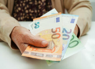 Občinam z romskimi naselji bo država zagotovila dodatna sredstva Retired elderly woman holding Euro banknotes money and worry about monthly expenses and treatment fee payment.