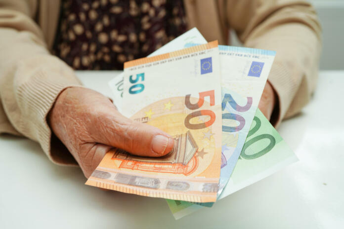 Retired elderly woman holding Euro banknotes money and worry about monthly expenses and treatment fee payment.