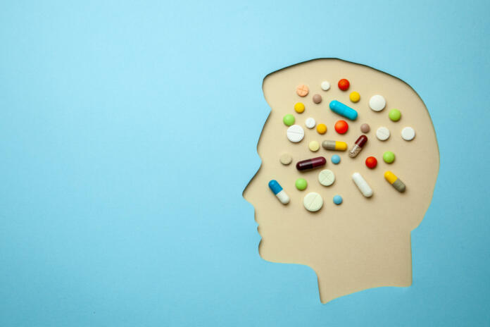 The profile of man and in his head lot of pills. Headache treatment.