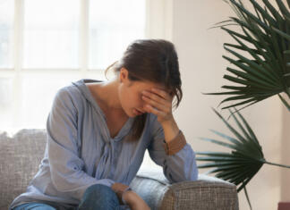 Splav in mrtvorod sta morda povezana s tem socialno-ekonomskim stanjem Upset depressed young woman feeling tired bad down headache migraine sitting on couch, sad desperate ashamed female in trouble having problem, regret mistake abortion, crying alone at home