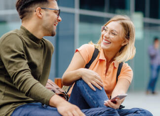 Bančni paket, ki paše v tvoj svet Mlad moški in ženska sedita in se smejita, ženska ima v roki mobitel