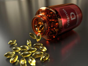 A medicine bottle turned over, outpouring vitamin D supplement capsules