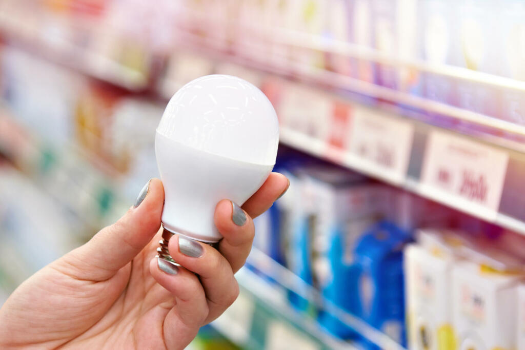Energy saving LED lamp in the hands of the buyer at the store