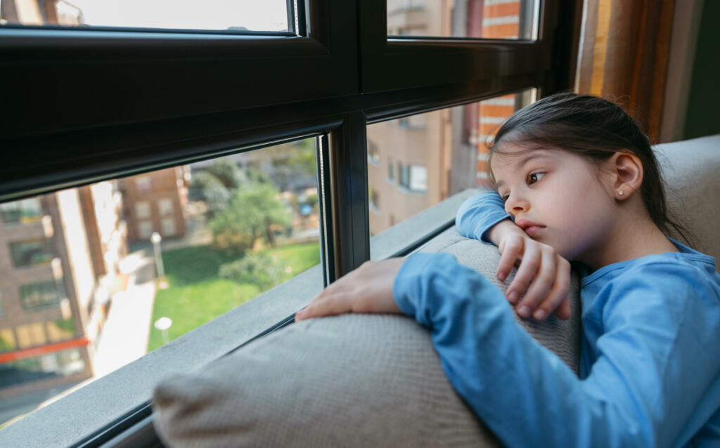 Girl looking out the window sad because she can't get out