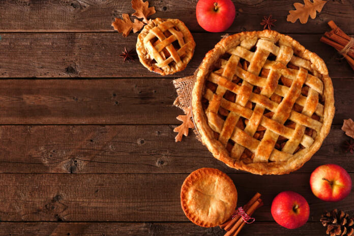 Homemade autumn apple pie corner border. Top view table scene over a rustic wood background with copy space.