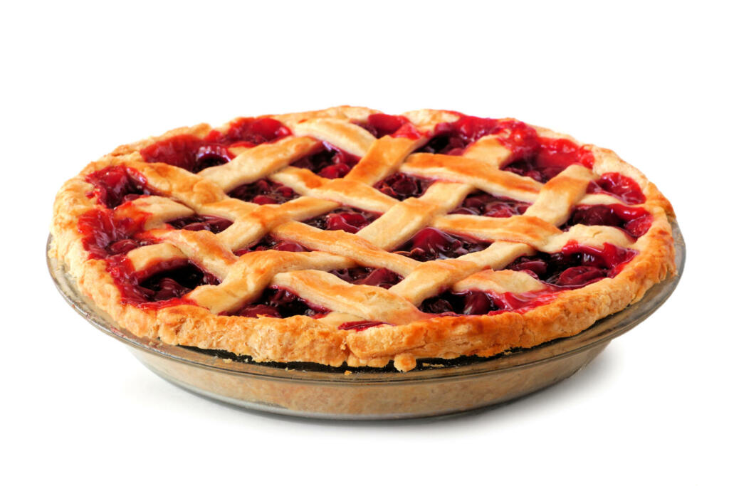 Homemade cherry pie with lattice pastry isolated on a white background. Side view.
