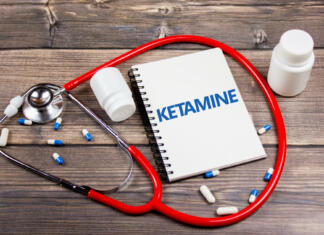 Kaj je ketamin? Droga, zdravilo, anestetik? Inscription KETAMINE on the notepad next to the pills. Ketamine is on the table.