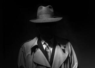 Vzpon in padec italijanske mafije: Kako so Italijani strli Cosa nostro Man posing in the dark with a fedora hat and a trench coat, 1950s noir film style character