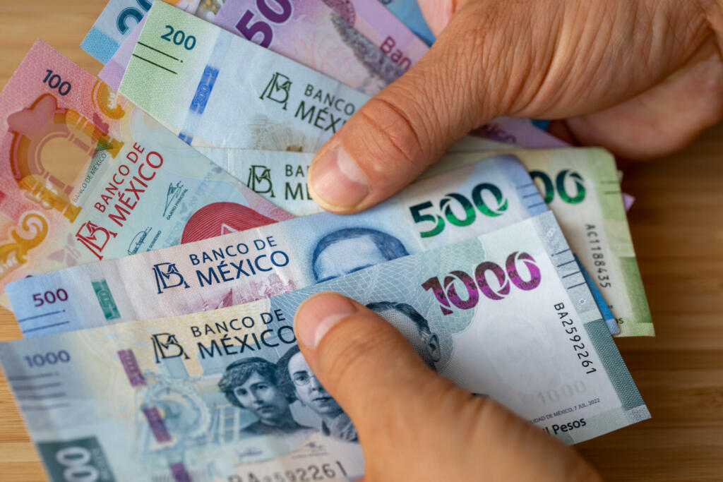 Mexico, Bundle of pesos banknotes held in hands, Financial concept, Mexican business success