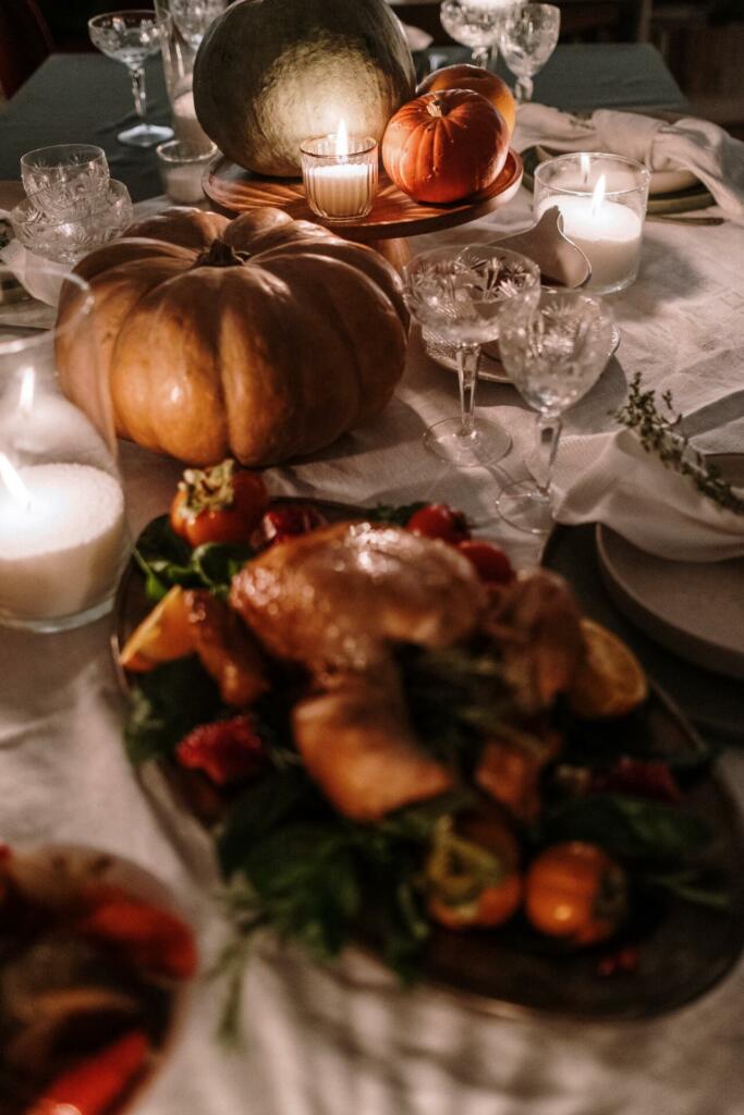 Pumpkins and lighted candles on dinner table