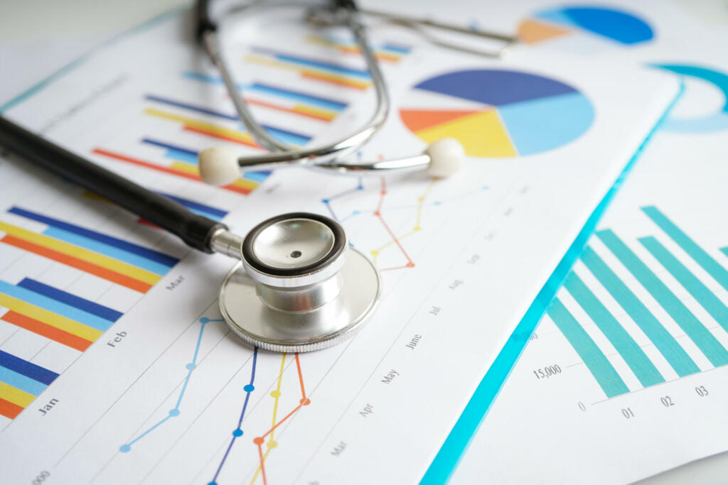 Stethoscope and US dollar banknotes on chart or graph paper, Financial, account, statistics and business data medical health concept.