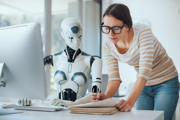 Woman and AI robot working together in the office, automation and technology concept