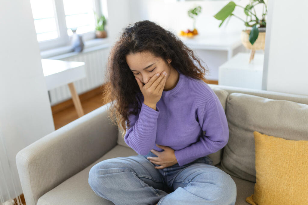 Closeup portrait of Asian unhappy, annoyed, sick woman about to chuck, throw up, puke retch barf. Negative emotions, feelings, facial expressions. Asian woman with morning sickness.