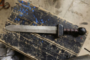 Details with an ancient Roman soldier's sword (gladius) during a historic reenactment event.