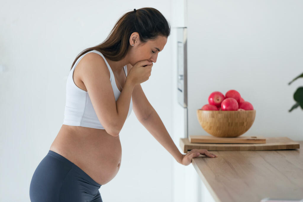 Shot of disgusted pregnant young woman suffering with nausea in morning at home.