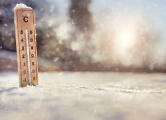 Kako pomagati pri ozeblinah? Thermometer in the snow with sub zero minus temperature concept for winter