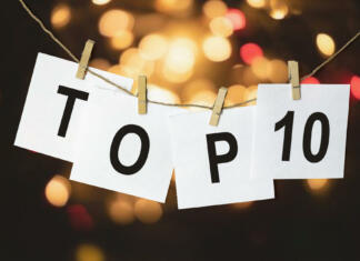 Najbolj poslušani albumi v letu 2023 white pieces of paper with the text Top 10 hang on a rope against a multicolored bokeh background