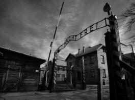 Auschwitz, Poland - March 28, 2008: Main gate of Auschwitz-Birkenau (Auschwitz I) concentration camp in Poland, where 1.1 million people where killed (90% Jews) by the Nazi army during the World War II (1940-1945). The Soviet troop liverated the camp on January 27 in 1945. In the following decades it became a symbol of the Holocaust. In 1947, Poland founded a museum on the site of Auschwitz I and II, and in 1979 it was named a UNESCO World Heritage Site.