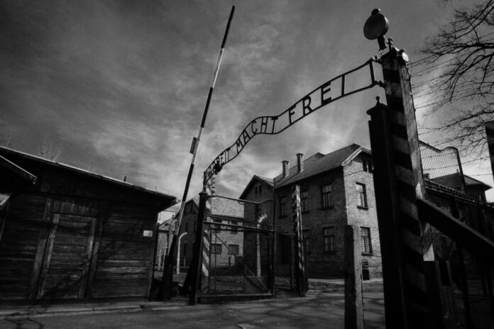 Auschwitz, Poland - March 28, 2008: Main gate of Auschwitz-Birkenau (Auschwitz I) concentration camp in Poland, where 1.1 million people where killed (90% Jews) by the Nazi army during the World War II (1940-1945). The Soviet troop liverated the camp on January 27 in 1945. In the following decades it became a symbol of the Holocaust. In 1947, Poland founded a museum on the site of Auschwitz I and II, and in 1979 it was named a UNESCO World Heritage Site.