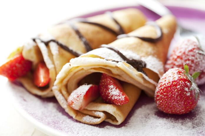 close up of two french style crepes, shallow dof. Some ingredients in the background