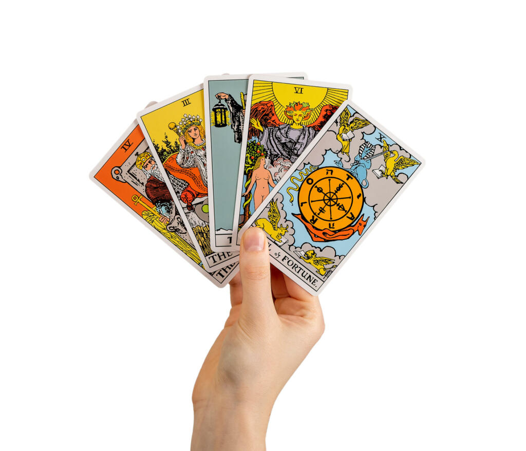 Hand holding tarot cards, major arcana isolated on white background.