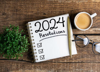 Top novoletne zaobljube leta 2024. Je tvoja med njimi? New year resolutions 2024 on desk. 2024 resolutions list with notebook, coffee cup on table. Goals, resolutions, plan, action, checklist concept. New Year 2024 template, copy space