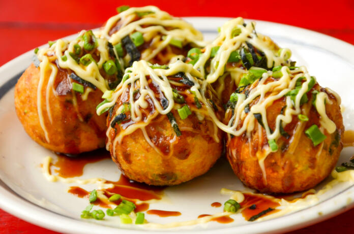 Takoyaki octopus balls - Japanese food, on red table.