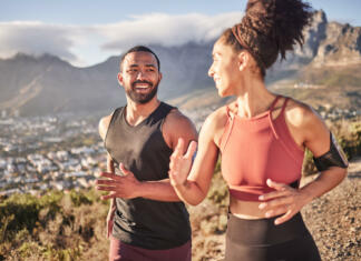 Kdaj telovaditi za najboljše rezultate? Ima znanost končno odgovor? Training, exercise and black couple running in nature for fitness, heart health and wellness. Sports, cardio and happy man and woman jog or runner workout outdoors preparing for marathon together.