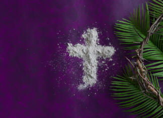 Pepelnična sreda – začetek 40-dnevnega posta Border of cross of ashes, palm branch leaves and partial crown of thorns on a dark purple background with copy space
