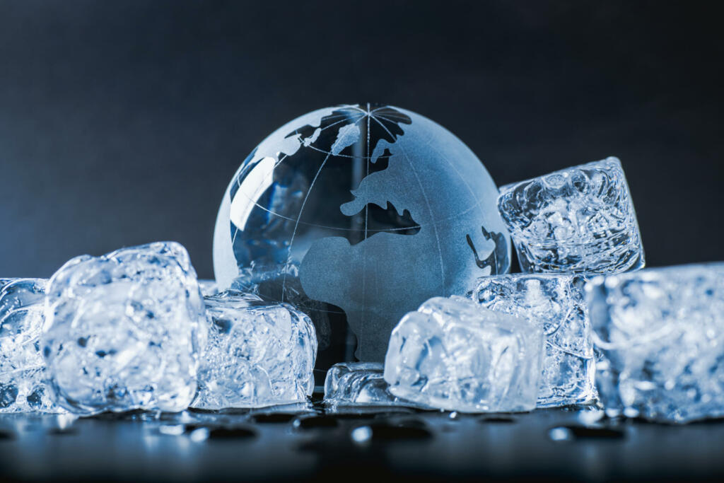 Globe is surrounded by ice cubes symbolizing new geological or political ice age