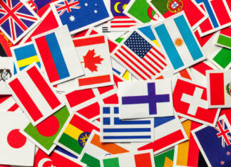 10 najbolj varnih držav v letu 2024 National flags of the different countries of the world in a heap. Top view