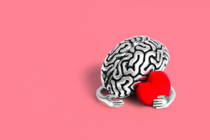 Valentine's Day card mockup: Steel brain holding a red heart on pink. Robust intellect and the delicate beauty of love.