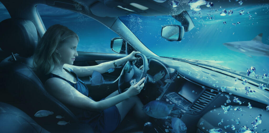 Beautiful woman drives the car on the bottom of the sea. Manipulation