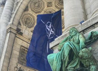 Zakaj obstaja zveza NATO? BRUSSELS, BELGIUM - JUNE 14, 2021: NATO flag fluttering in the wind in the arcades of the Cinquantenaire in Brussels