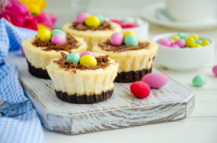 Easter mini brownie cheesecake Bird's Nest with chocolate and candy eggs. Easter dessert. Funny food idea for children. Horizontal orientation. Selective focus. Close up.