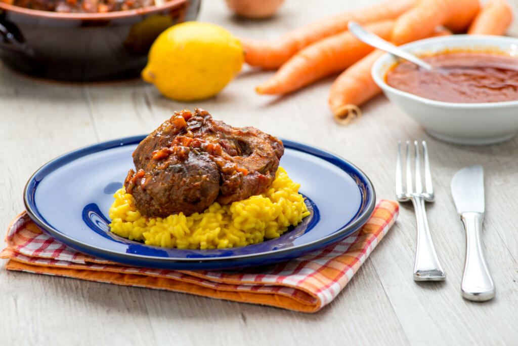 Italian yellow risotto with stew served in a blue dish