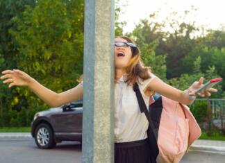 Ali ta lastnost pomeni manj inteligentno osebo? Podrobna raziskava odgovarja Portrait of young inattentive girl, distracted by mobile phone. Girl crashed into street post, dropped phone