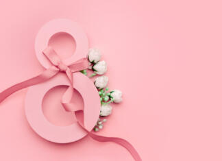 8. marec doma in po svetu: Kako svet obeležuje dan žena? Postcard March 8. Greeting card from March 8. Paper number eight decorated with white small spring flowers and green leaves on a pink background