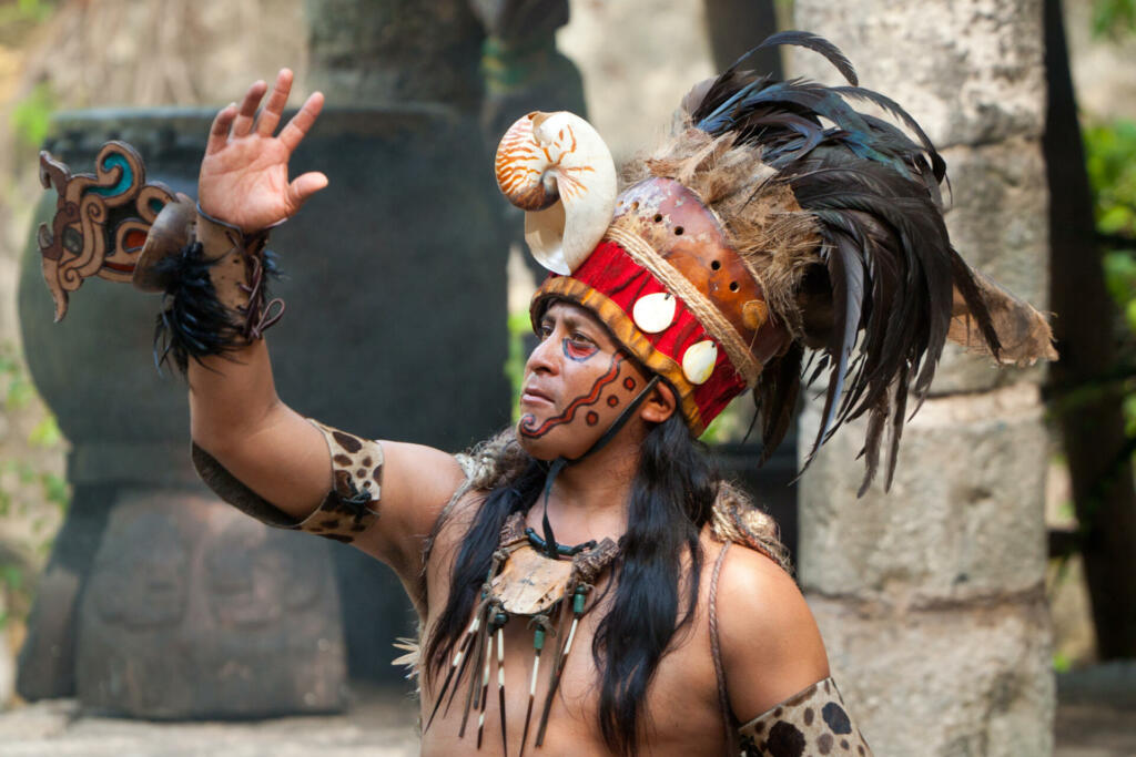 Xcaret,Mexico - July 19, 2011 Unkown man in Mayan shaman uniform beginning traditional Mayan performance in the jungle of Xcaret park. This is the most famous Mayan performance in Mexico.