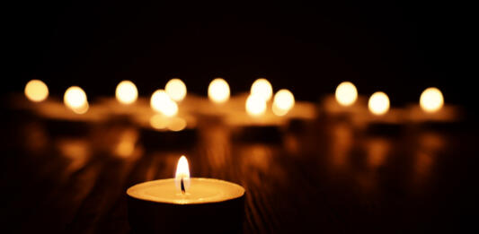 Burning candle over black background