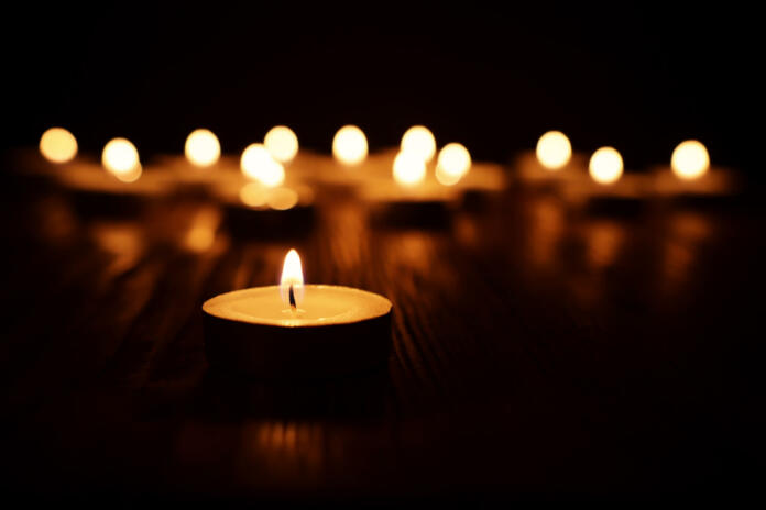 Burning candle over black background