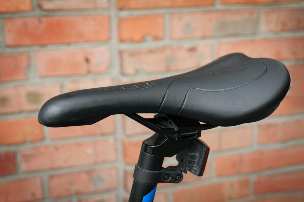 Close-up of a black saddle of a modern mountain bike. Outdoors.