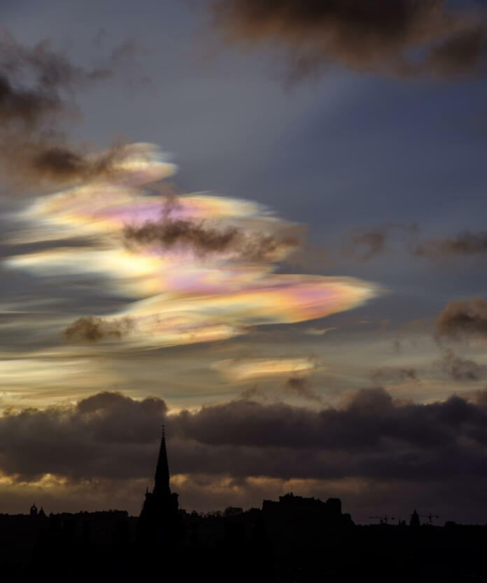 Edinburgh skyline silhouetted against early morning sky with beautiful rare nacreous clouds.