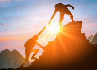 Slovnični nasvet: zakaj gremo NA goro in V gore? Help and assistance concept. Silhouettes of two people climbing on mountain thanks to mutual assistance and teamwork and partnership. business success and teamwork concept in company