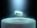 Image concept of magnetic levitating above a high-temperature superconductor, cooled with liquid nitrogen.