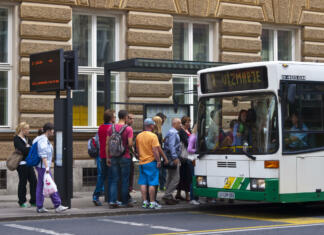 Aplikacija, ki jo v prestolnici preprosto moraš uporabljati Ljubljana, Slovenia - july 26, 2011: A view of the people in line and slowly going on the bus at bus station in front of main Post office in center of Ljubljana. On left side is panelwith bus line nimber and time when it will leave.